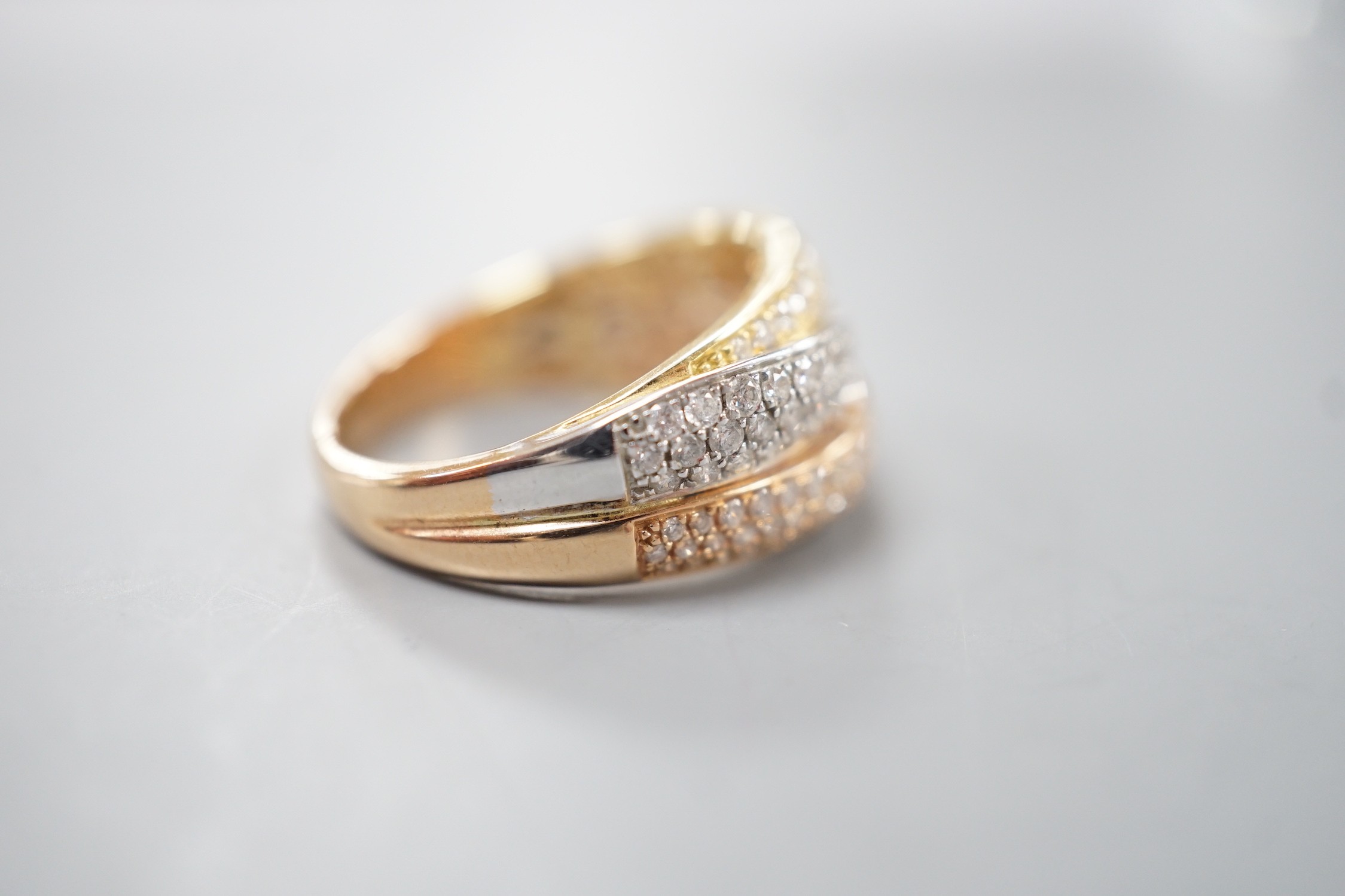 A modern three colour 18ct gold and diamond chip set triple band crossover ring, size O, gross weight 7 grams.